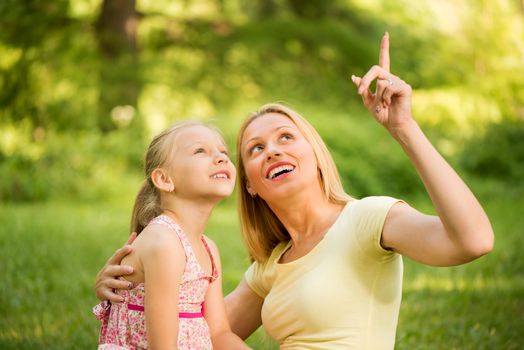 Happy cute little girl with mother in the park