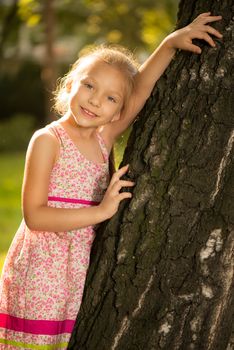 Cute little girl on the tree in the park