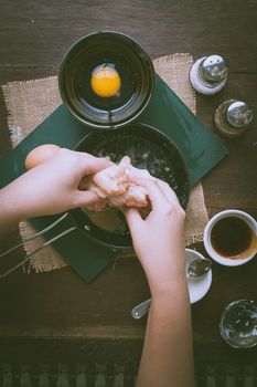 Preparation for cooking in home kitchen. Woman hand mixing ingredients with chicken wings with vintage filter effect.