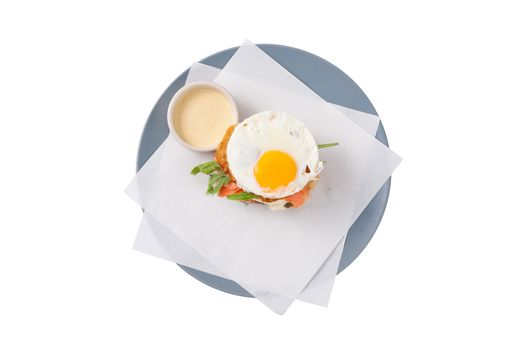 Grilled sandwich with bacon and fried egg in grey dish isolated on white background with clipping path