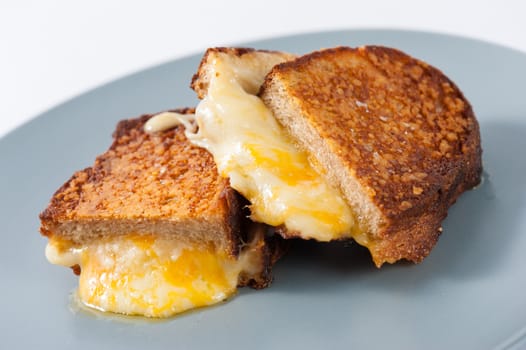 Toasted sandwich with various types of  cheese in ceramic dish