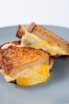 Toasted sandwich with various types of  cheese in ceramic dish