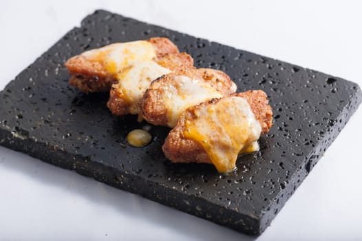 Deep fried chicken wings dressed with various types of cheese