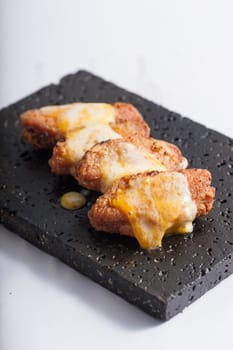 Deep fried chicken wings dressed with various types of cheese