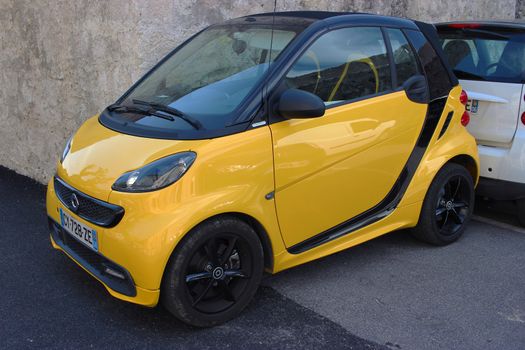 Saint-Paul-de-Vence, France - March 22, 2016: Yellow Smart Fortwo Cityflame Parked in the Street of Saint-Paul-de-Vence, France