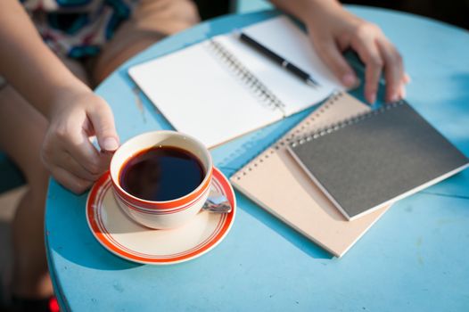 Woman right hand holding coffee cup during coffee break in cafe with morning scene