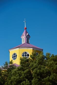 Bright yellow and purple painted facade of the historic Iglesia San Francisco in Castro, capital of the island of Chiloé in Chile.