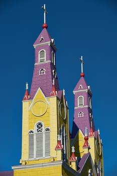 Bright yellow and purple painted facade of the historic Iglesia San Francisco in Castro, capital of the island of Chiloé in Chile.