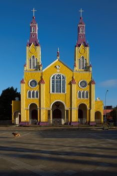 Bright yellow and purple painted facade of the historic Iglesia San Francisco in Castro, capital of the island of Chiloé in Chile.