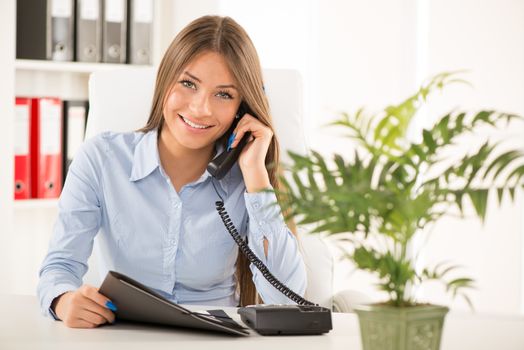 Beautiful Businesswoman telephoning and working in the office.