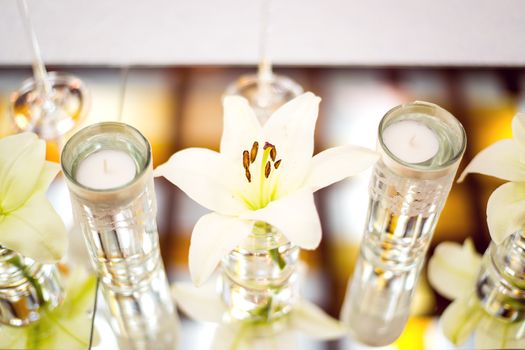Wedding table decoration with flowers, candle and glassware