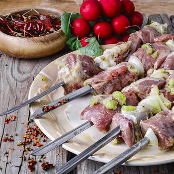 raw meat with vegetables threaded onto a skewer for roasting on the coals