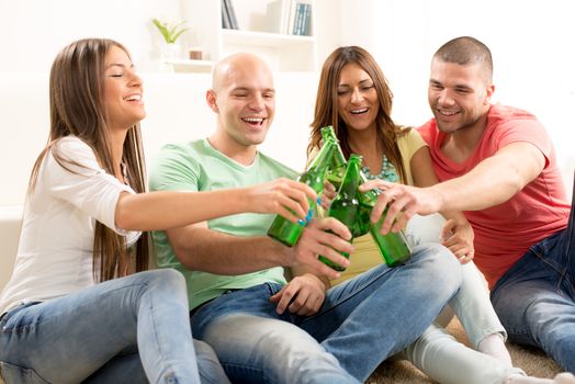 Friends enjoying with beer and cheers together at home party.