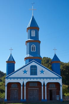 Facade of historic wooden church, Iglesia de Tenaun, built in the 17th century by Jesuit missionaries on the island of Chiloe in Chile.