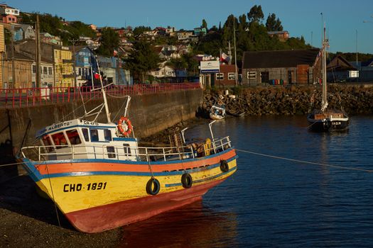 Colourful fishing boat resting on the shore in Castro, capital of the Island of Chiloe in Chile.