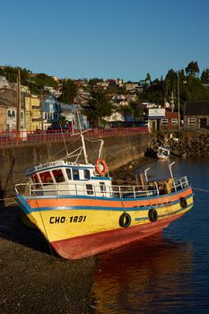 Colourful fishing boat resting on the shore in Castro, capital of the Island of Chiloe in Chile.
