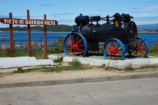 Old steam engine in a coastal garden in Quellon, a fishing town on the Island of Chiloe in southern Chile.