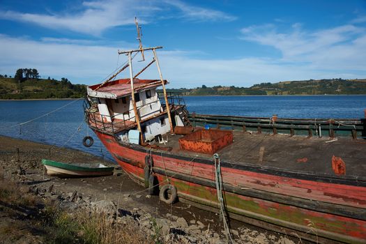 Derelict fishing boat stranded on the shore in Castro, capital of Chiloe Island in Chile.