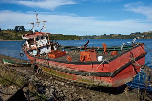 Derelict fishing boat stranded on the shore in Castro, capital of Chiloe Island in Chile.