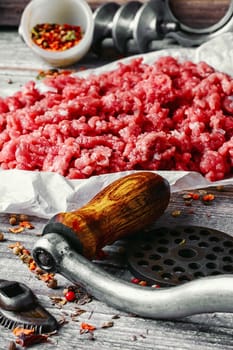 Fresh ground beef with spices on paper for baking