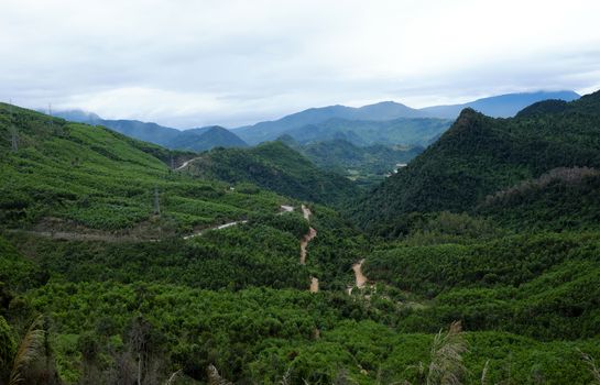 Scene on Ho Chi Minh trail on clouds day, house on hill, danger terrain with mountain pass, people cross stream, life on highland Vietnam among green forest