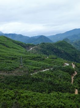 Scene on Ho Chi Minh trail on clouds day, house on hill, danger terrain with mountain pass, people cross stream, life on highland Vietnam among green forest