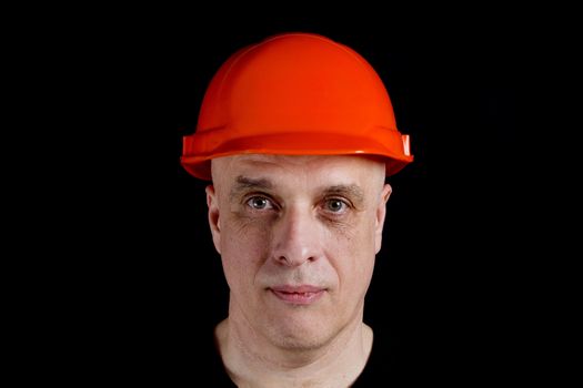 Construction worker in orange protective helmet on a gray background