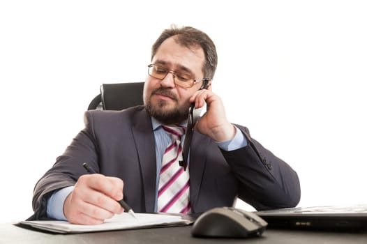 the businessman communicates by phone sitting at a table and makes entry