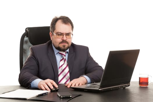 the businessman sits at office table with the laptop