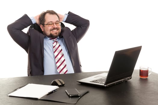 the businessman sits at office table with the laptop