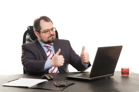 the businessman sits at office table with the laptop