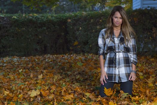 Young woman kneeling in dead leaves