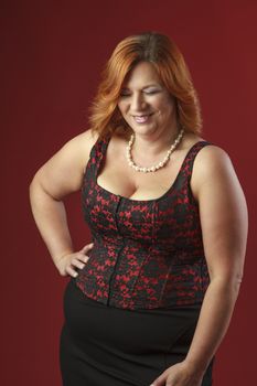 woman in her fortie wearing a red corset, laughing