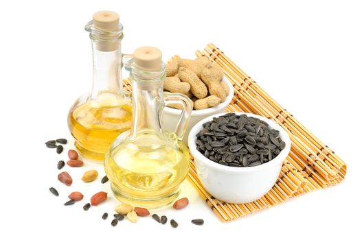 Sunflower seeds, peanuts and bottle of oil isolated on a white background                                    