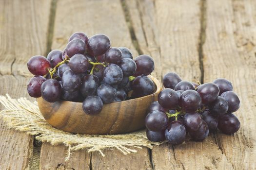 grapes in a bowl on wooden background