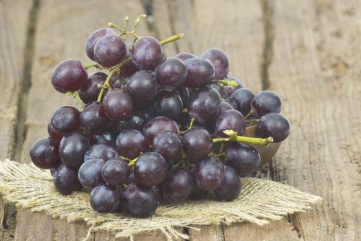 grapes in a bowl on wooden background