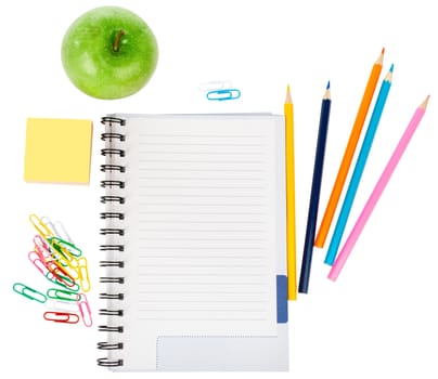 Open notebook with stationery and apple isolated white background, closeup