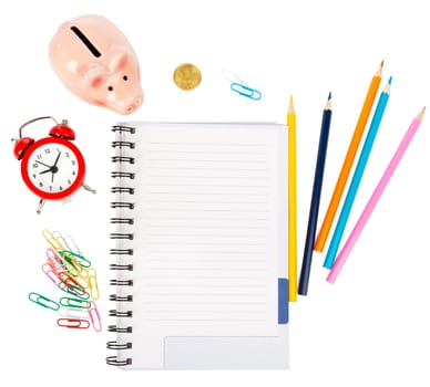 Open notebook with stationery and piggy bank isolated white background, closeup