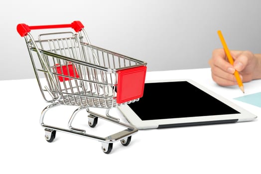 Females hand using tablet isolated on white background with shopping cart