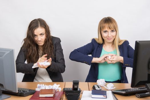 Employees of office paper crumpling up to something