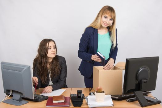 An employee in the office watching colleague who happily collects things
