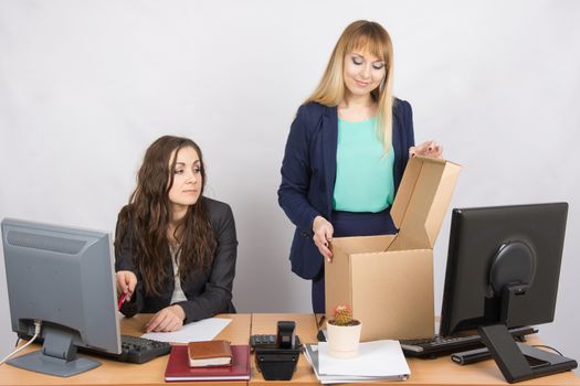 An employee in the office watching a new colleague who arranges things