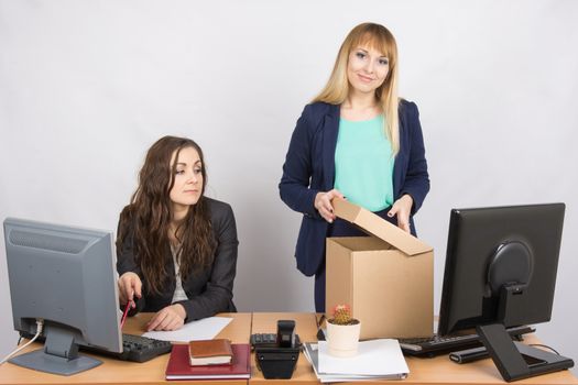  New employee in the office happily arranges things, next to a colleague
