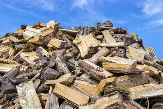 Big heap of chopped tree trunks for heating season in winter