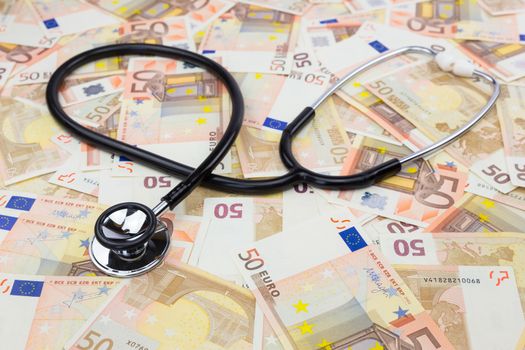 Black professional stethoscope lying on many euro bills