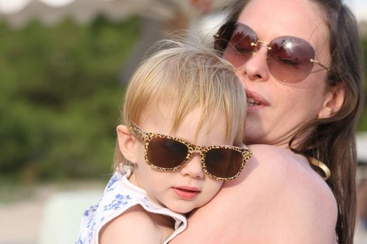 Portrait of mother and her baby girl posing with glasses
