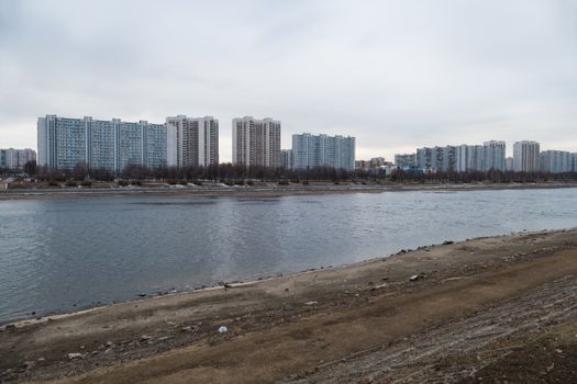 Urban river and houses and shore beneaped