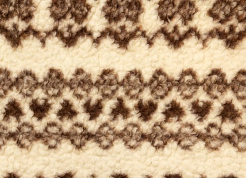 Close-up of knit fabric background with knitted grey and white geometric pattern