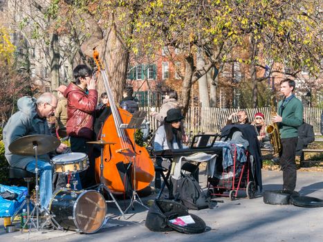 Manhattan, New York - December 06, 2015: Team of street musicians playing during lazy Sunday afternoon in Washington Square Park.