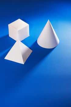 Geometry concept. Set of various paper shapes on blue background